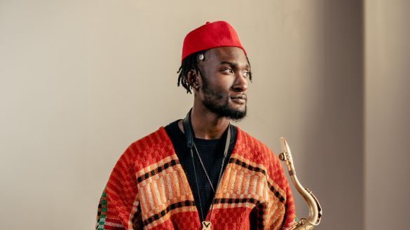 Image of Isaiah Collier holding his saxophone. 