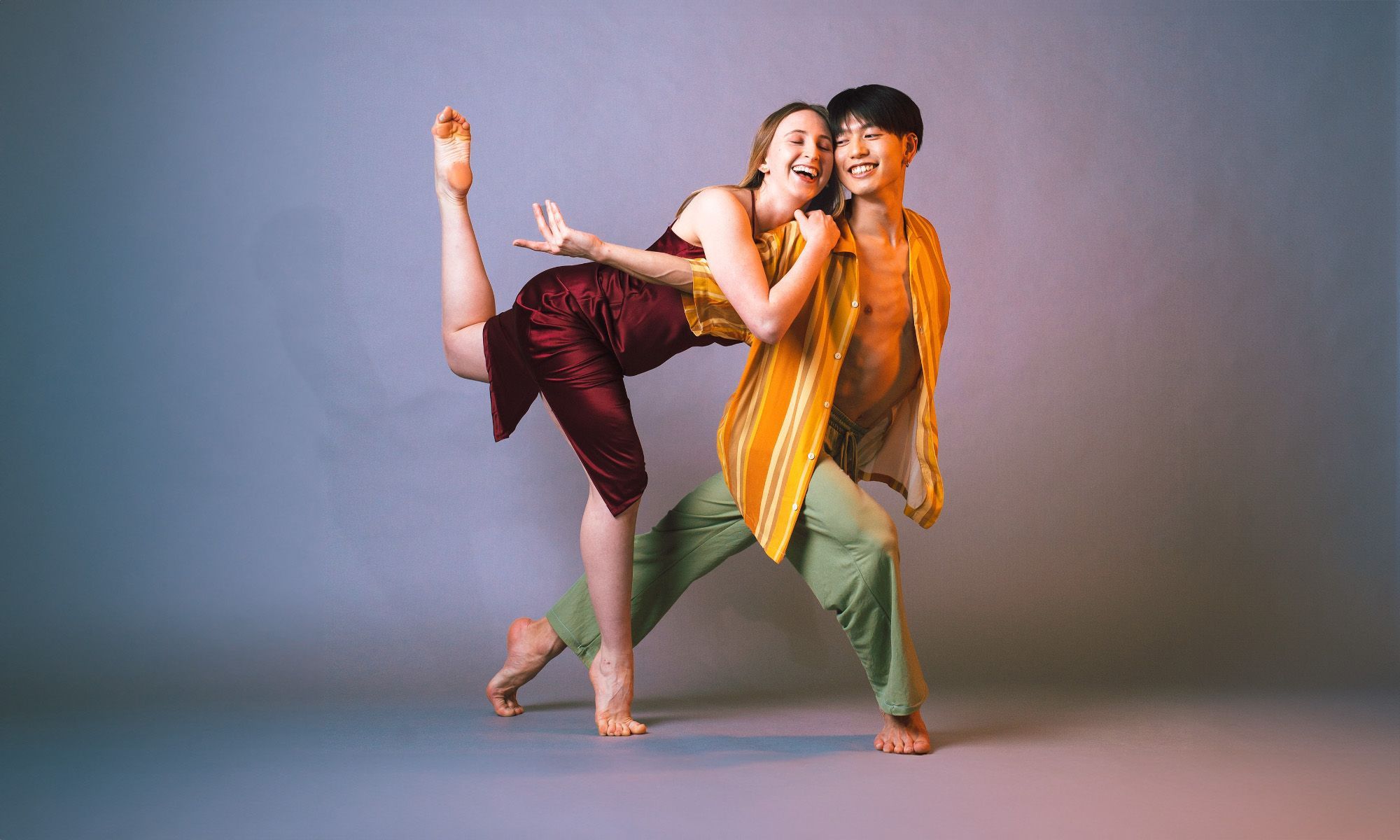 Two dancers laughing together as they pose.